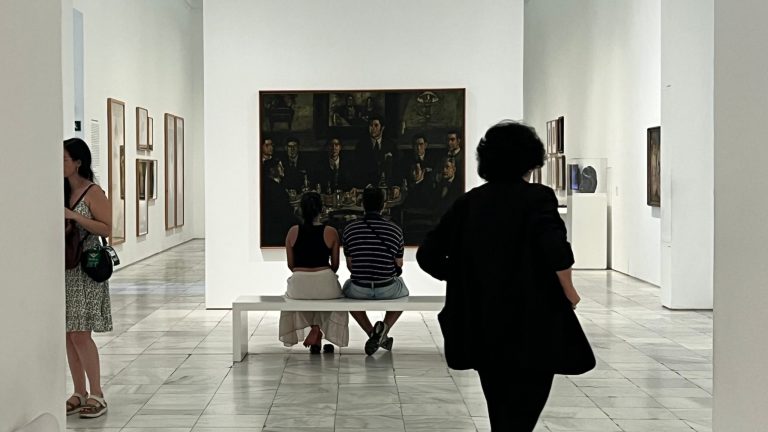 Visitantes contemplan "La tertulia del Café Pombo", de José Gutiérrez Solana, en el Museo Reina Sofía. The guides you need